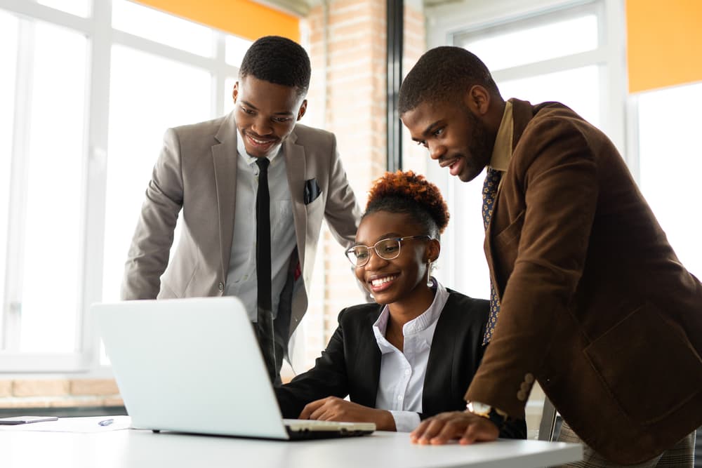 Three colleagues reviewing building plans together at a table