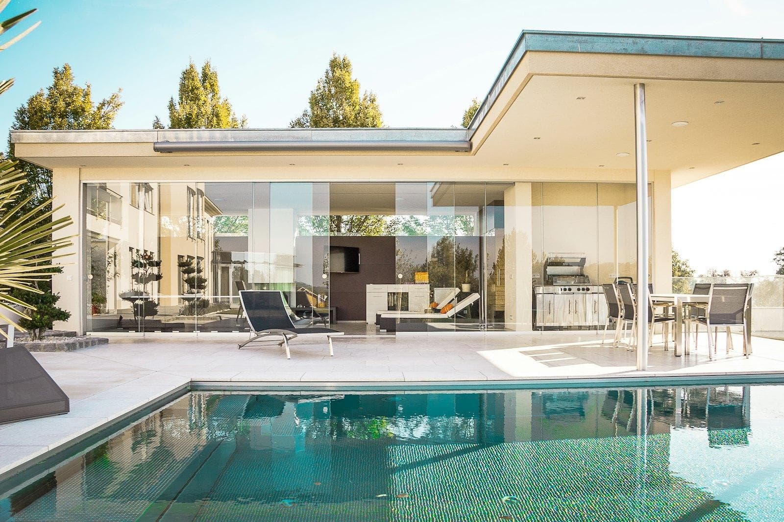 A contemporary home with a stone facade and a glass balcony